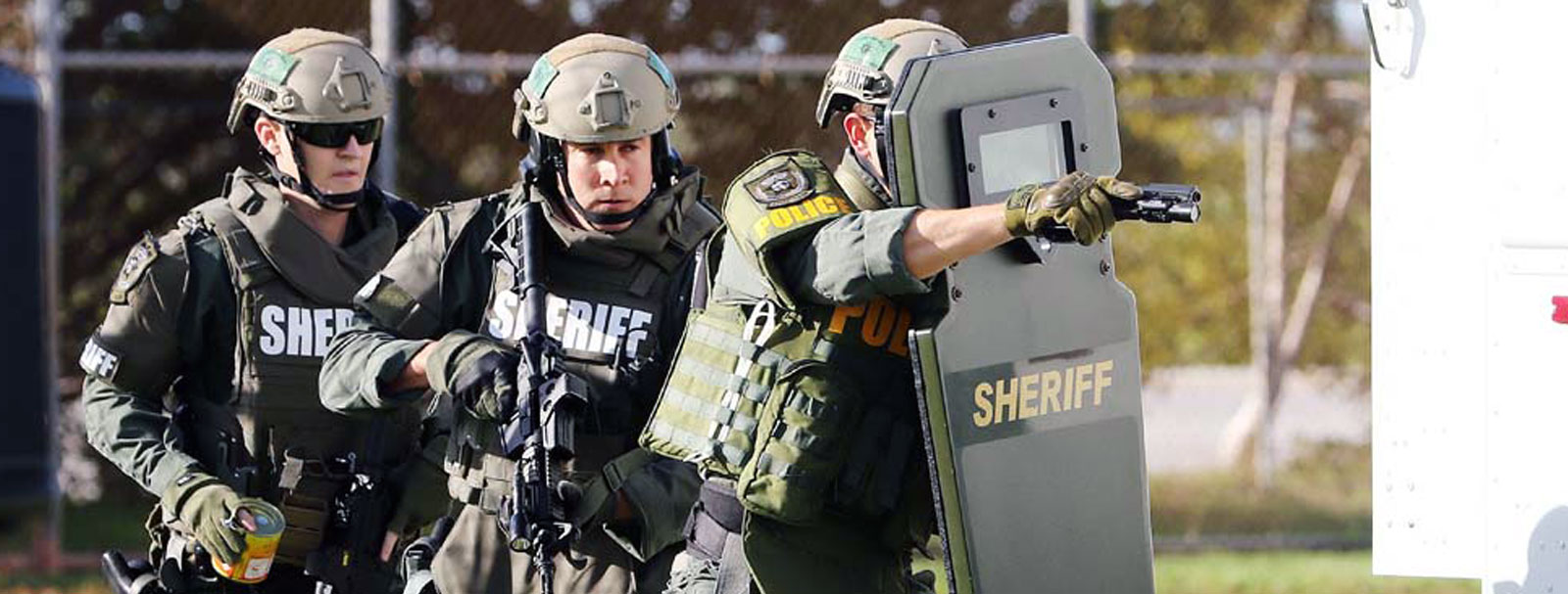 Sheriff's deputies advancing behind an A.A.M. ballistic shield